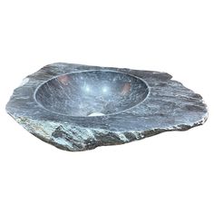 a stone bowl sitting on top of a rock