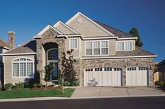 a large house with two garages in front of it