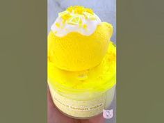 a hand holding a yellow cup filled with ice cream