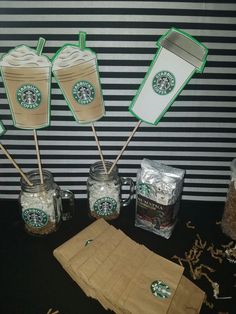 starbucks drink stirrers are sitting in front of some coffee bags and paper straws