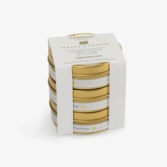 six gold and white coasters stacked on top of each other in a cardboard box