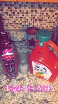 a counter top with two bottles and a blender sitting next to each other on it