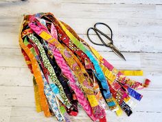 a pair of scissors sitting on top of a table next to some colorful ribbons and ties