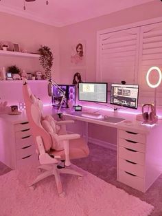 a pink room with two computer screens on the desk and a chair in front of it