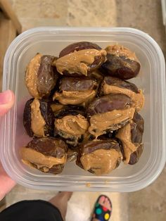 a plastic container filled with chocolate covered dates