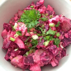 a white bowl filled with red cabbage and celery garnished with parsley