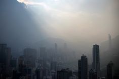 the sun shines through the clouds over a cityscape in hong kong, china