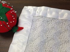 a close up of a piece of cloth with a strawberry on it next to a pillow