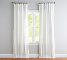 a white curtain hanging in front of a window