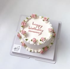 a white birthday cake with pink roses on it