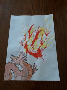 a piece of paper with a drawing of a dragon and fire coming out of it