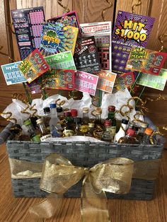 a gift basket filled with lots of liquor and cards on top of a wooden table