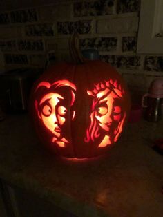 a carved pumpkin with the faces of two people on it