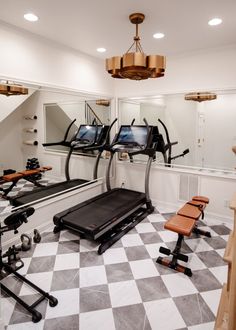 an exercise room with treadmills and mirrors