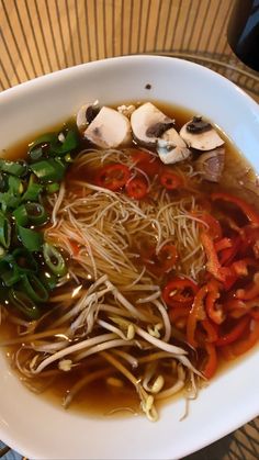 a white bowl filled with noodles and vegetables