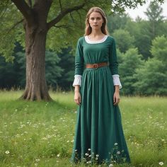 This graceful medieval dress is designed to a flowy length that opportune flows onto the floor gracefully. A close-fitted bodice has a round neck with an outer dark gray color collar adding on to the noble outlook of the dress. Long sleeves clinch at the wrists with a discreet rustic brown cuff to allow gentle puff and increase the historic charm of the outfit. At the waist, it is framed by a wide, dark brown leather belt that offsets the silhouette against the deep green of the dress. At the ba Peasant Style Long Sleeve Costume Dress, Elvish Long Sleeve Dresses For Medieval Festivals, Long Sleeve Dresses For Medieval Festivals, Medieval Long Sleeve Prairie Dress, Regency Style Long Sleeve Medieval Dress, Regency Style Long Sleeve Medieval Dress For Festivals, Historical Long Sleeve Medieval Dress For Cosplay, Regency Style Medieval Dress For Larp And Festivals, Green Medieval Dress