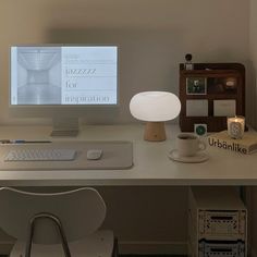 a desk with a computer, lamp and other items on it