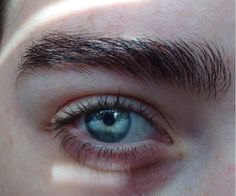 a close up view of an eye with blue eyes