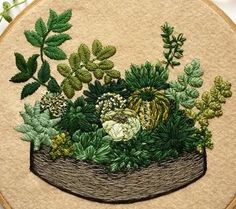 an embroidery project with green plants and leaves