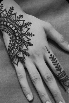 a woman's hand with henna tattoos on it