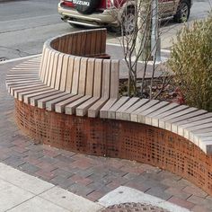 a curved bench sitting on the side of a road