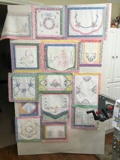 a white refrigerator covered in lots of different types of quilts and appliques