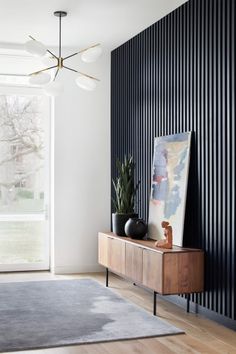 a living room with a large window and a painting on the wall next to it