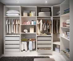 an organized closet with white drawers and shelves