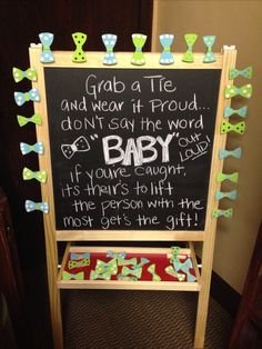 a baby shower sign with green bows on it and the words grab a tie and we're at proud, don't say the word