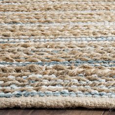 an area rug with blue and white stripes on the top, sitting on a wooden floor