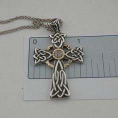 "Sterling Silver Celtic Knot Cross Oxidized background with 10K Gold Accents & White Sapphires 1 & 1/16\" wide 1 & 7/8\" long Sterling Silver 18\" chain with clasp. Nicely boxed with silver cloth. Celtic Cross by Keith Jack Jewelry Imported from Canada Signed by the Artist In Stock! Ships Immediately." Hallmarked Cross Jewelry For Anniversary, Engraved Cross Pendant Jewelry For Anniversary, Elegant Collectible Cross Necklaces, Elegant Cross Necklace For Collectors, Anniversary Hallmarked Cross Jewelry, Elegant Cross Jewelry For Collectors, Elegant Cross Collectible Jewelry, Jewelry Cross Necklace, Celtic Knot Cross