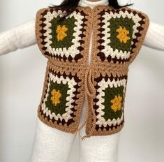 a crocheted vest with leaves on the front and sides, made to look like a granny's sweater