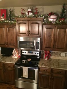 a kitchen decorated for christmas with wooden cabinets and stainless steel stove top oven in the center