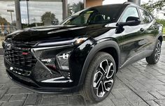 a black chevrolet suv parked in front of a building