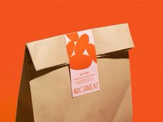 a brown paper bag with an orange and white tag on the side that says arciweat