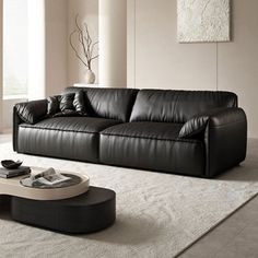 a black leather couch sitting on top of a white rug