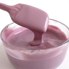 a glass bowl filled with pink liquid and a spoon sticking out of the top one