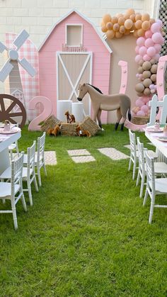 tables and chairs are set up in the grass for a farm themed birthday party with balloons