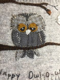 an embroidered owl sitting on top of a tree branch with the words happy outpour written across it