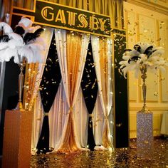 the entrance to gatsby is decorated with white and black feathers, gold sequins, and streamers