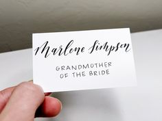 a hand holding up a business card that reads marleen simpson grandmother of the bride