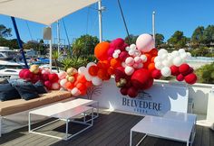 balloons are hanging from the roof of a boat at a party or event with tables and couches