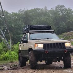 a jeep parked on the side of a dirt road in front of a power line