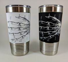 two stainless steel tumblers with different types of hands and bones on them, side by side