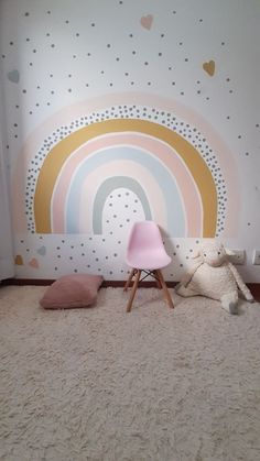 a child's room with a rainbow wallpaper and pink chair in the corner