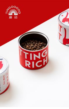 two tins with coffee beans in them sitting on a table next to each other