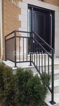 a black metal hand rail on the outside of a building