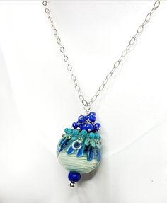 Another AMAZING handmade glass lampwork bead - the vivid blue and green hues are just incredible! It's even more lovely in person, especially with the gorgeous crown of matching Lapis Lazuli. So much about this pendant is wonderful. It is truly a one of a kind creation!   Lovingly handcrafted, just for you. Thank you for your interest!  All metal components are .925 Sterling Silver All gems are AAA rated and genuine - NOT lab-created or synthetic Handmade Artisan Glass Lampwork Bead - custom handmade, NOT commercially made or mass produced Handmade, One of a Kind Ready to ship This item comes in a gift box and is ready for gift giving. You will receive the exact item in this listing. Please send me a convo with any questions or special requests. Thank you for your interest! Unicorn Glass, Unique Polished Blue Beads, Blue Beaded Murano Glass Jewelry, Forest Necklace, Elegant Blue Murano Glass Necklace, Glass Lampwork, Luxury Artisan Blue Beads, Gems And Cabochons, All Gems, Rain Forest