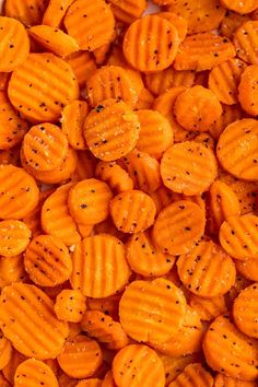 closeup of sliced carrots with seasoning on them in a white dish bowl