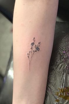 a small flower tattoo on the arm